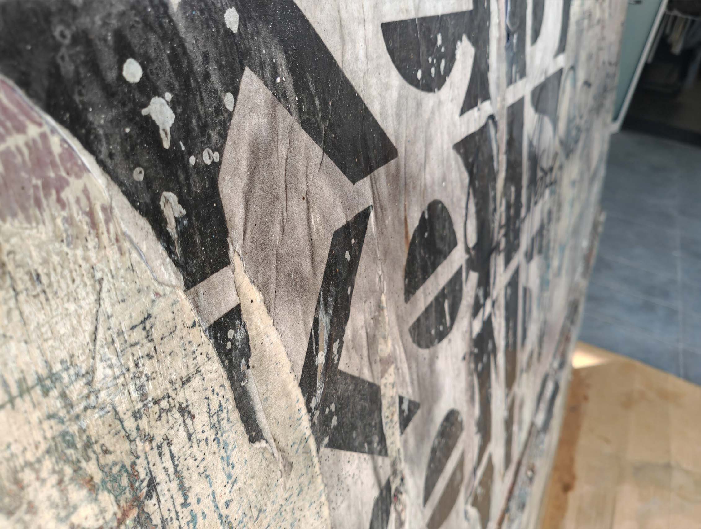 Putas sviluppa il linguaggio della calligrafia urbana attraverso una composizione monumentale e stratificata dove segni, abrasioni e sovrapposizioni costruiscono una superficie pittorica intensa e contemporanea. Il formato panoramico enfatizza la relazione tra scrittura, ritmo e spazio architettonico, mantenendo la tensione visiva tipica della ricerca di Kende.