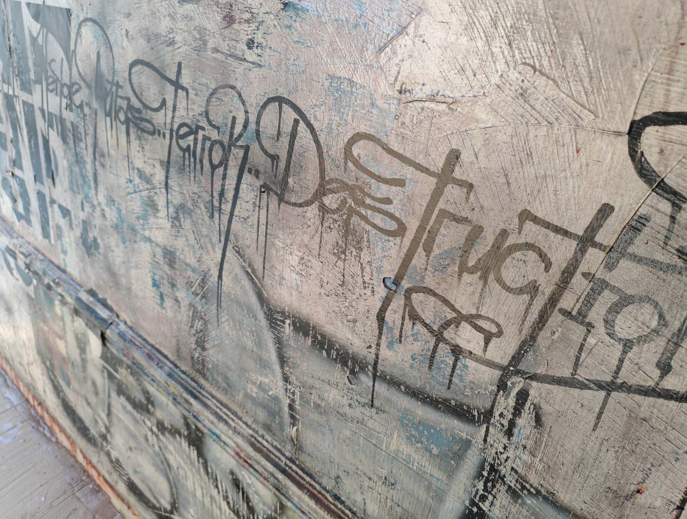 Putas sviluppa il linguaggio della calligrafia urbana attraverso una composizione monumentale e stratificata dove segni, abrasioni e sovrapposizioni costruiscono una superficie pittorica intensa e contemporanea. Il formato panoramico enfatizza la relazione tra scrittura, ritmo e spazio architettonico, mantenendo la tensione visiva tipica della ricerca di Kende.