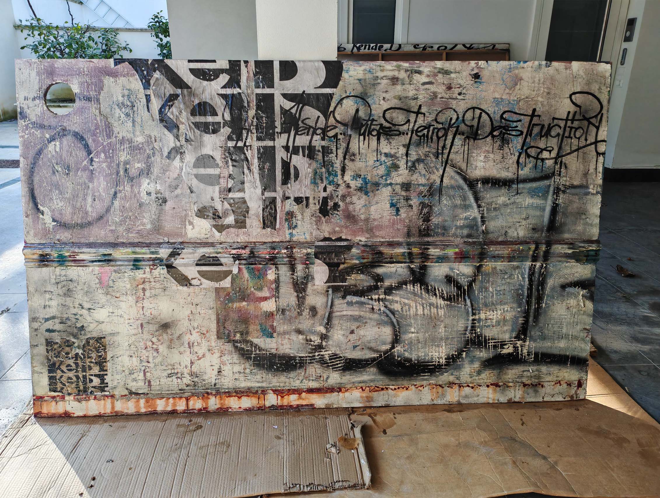 Putas sviluppa il linguaggio della calligrafia urbana attraverso una composizione monumentale e stratificata dove segni, abrasioni e sovrapposizioni costruiscono una superficie pittorica intensa e contemporanea. Il formato panoramico enfatizza la relazione tra scrittura, ritmo e spazio architettonico, mantenendo la tensione visiva tipica della ricerca di Kende.
